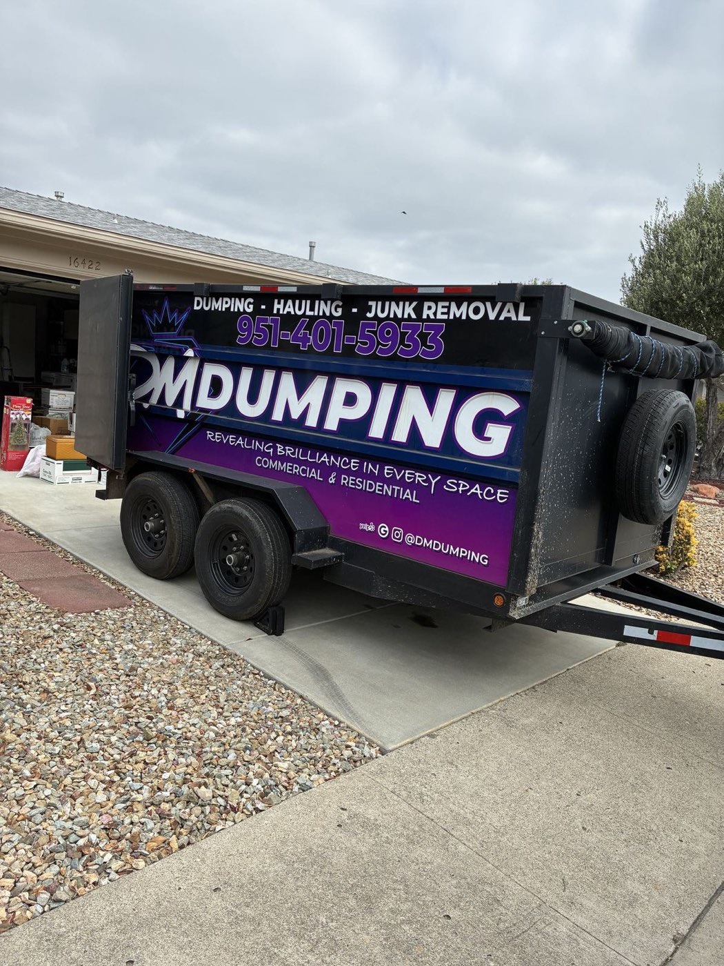 DMD dump trailer on a residential driveway, ready to load