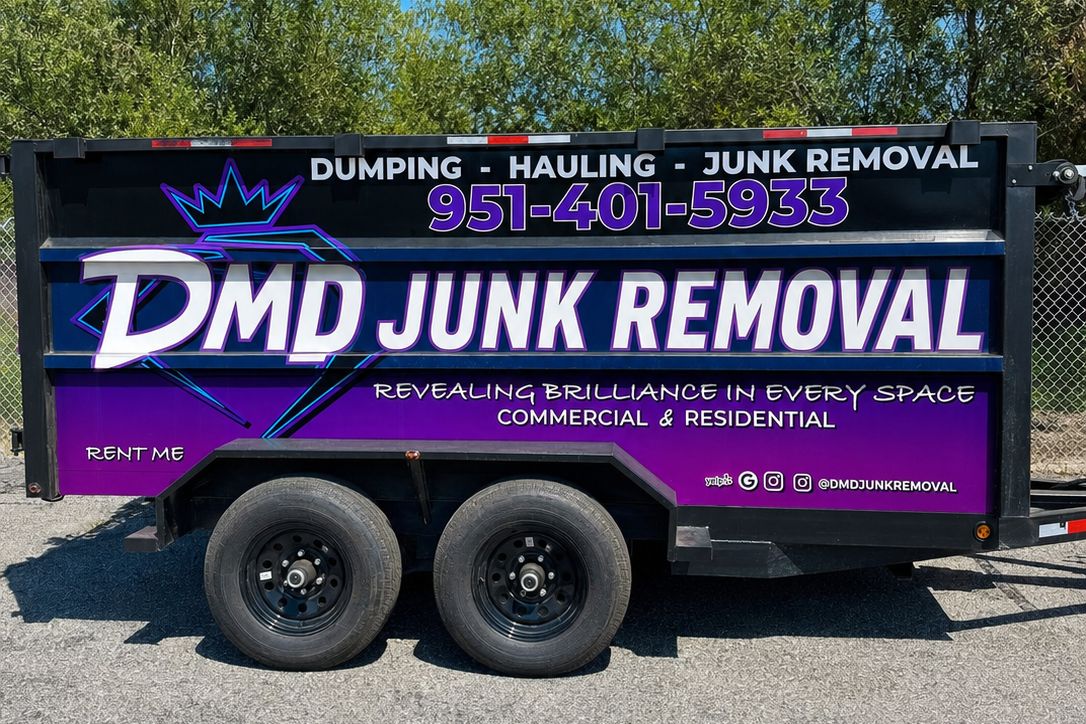 Side of the DMD dump trailer showing the DMD JUNK REMOVAL wrap, RENT ME lettering and phone number 951-401-5933